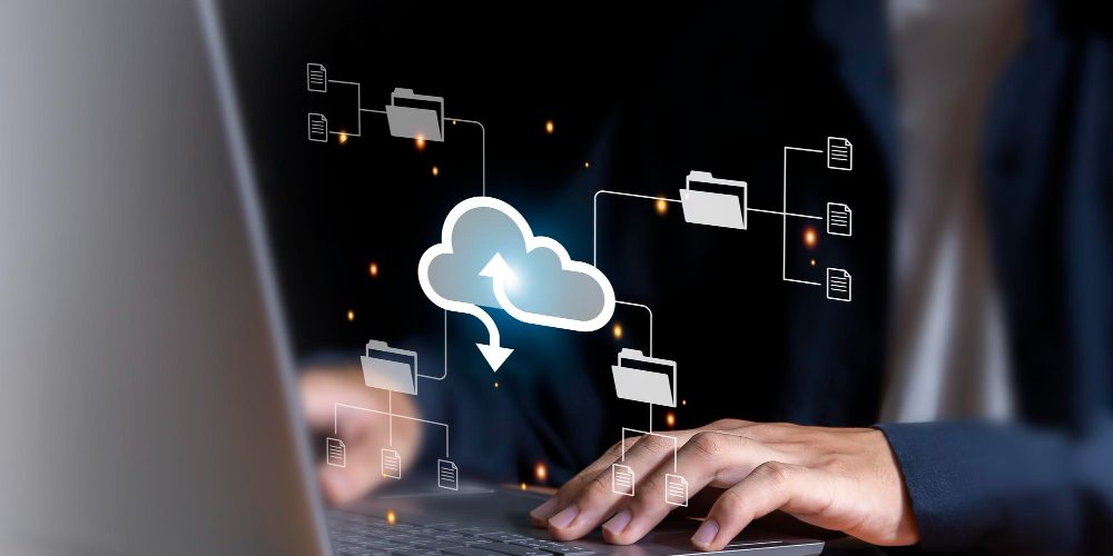 2075 A person typing on a laptop with digital icons of cloud storage and file folders floating above the keyboard, representing cloud computing or data management.